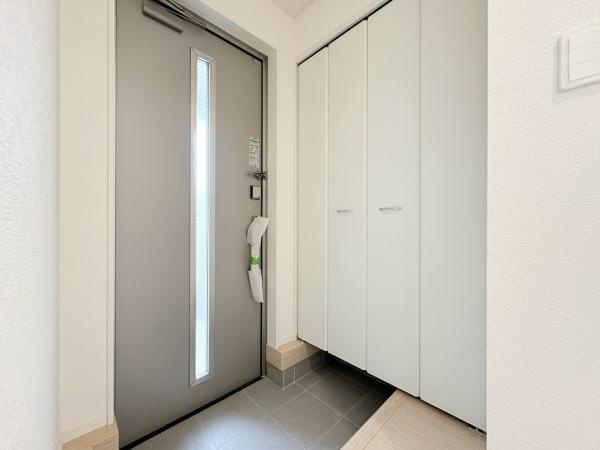藤沢市城南２丁目の新築一戸建の玄関|玄関には大きな収納スペースがあり整理整頓しやすい設計です。シンプルなデザインのドアが空間を明るく演出します。玄関の床はお手入れしやすい素材を採用しています。採光窓付きで昼間は自然光が差し込みます。