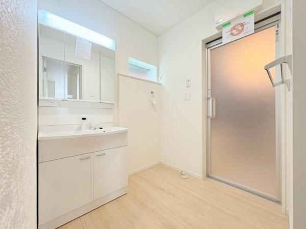 藤沢市城南２丁目の新築一戸建の独立洗面台|清潔感のある洗面台が設置されており室内全体が明るく仕上がっています。収納スペースも確保されていて使い勝手の良さが感じられます。床の色味が落ち着いており空間に調和しています。