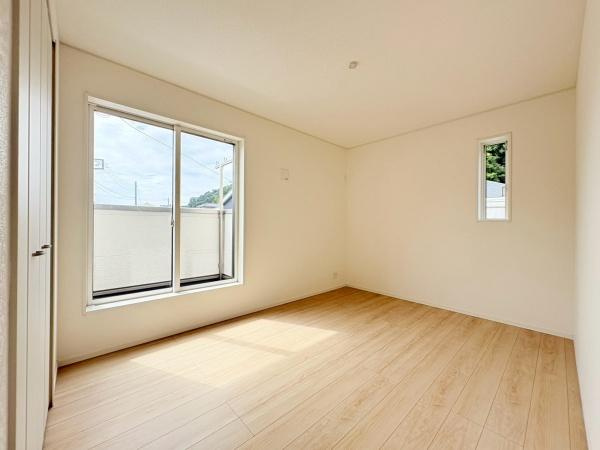 藤沢市城南２丁目の新築一戸建の寝室|ナチュラルなフローリングが特徴の寝室です。大きな窓からはしっかりとした採光があり明るい雰囲気です。シンプルな内装でインテリアが合わせやすい空間です。小窓もあり通風も良好です。