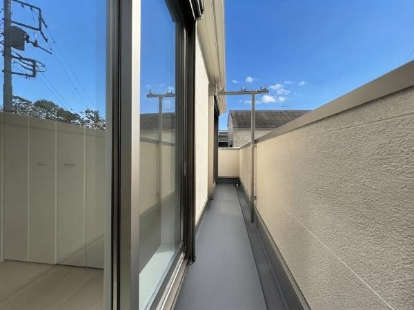 藤沢市城南２丁目の新築一戸建のバルコニー|壁に囲まれたプライベート感のあるバルコニーです。窓からのアクセスも快適で使いやすいスペースが広がっています。奥行きがありゆったりとした雰囲気を感じられます。晴れた日には空も広く望めます。