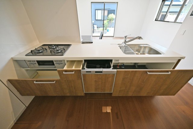 テラシエ箕面市石丸2丁目新築戸建のキッチン|広いワークトップはお料理の盛り付けに便利。シンク下の収納スペースには大きなお鍋やフライパンなどの大きな調理器具もスッポリ収納できます。又、食洗機付なので食後の片づけもスムーズです。