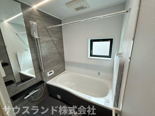 八王子市兵衛 新築戸建ての浴室|落ち着いた色合いのパネルがリラックス空間を演出する浴室です！足を伸ばしてゆっくり浸かれる広い浴槽で、一日の疲れをしっかり癒やせます。小窓が付いているため換気がしやすく、カビの発生を抑えて清潔に保てます