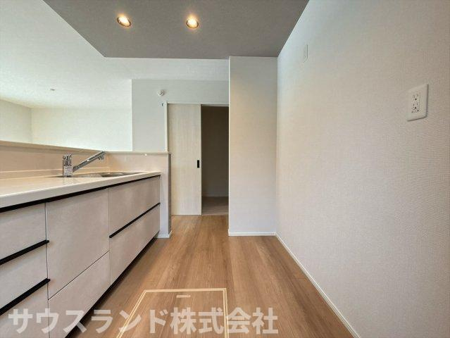 八王子市兵衛 新築戸建てのキッチン|背面にお揃いのカップボードを備えた、収納力抜群のシステムキッチンです！食器や調理家電もすっきりと収まり、いつでも整理整頓された綺麗な空間を保てます。木目調の床とマッチしたお洒落なデザインです♪
