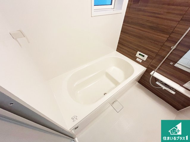 ■尼崎市神田中通　新築一戸建ての浴室|足をゆったり伸ばして寛げる浴槽です。窓が設けられていますので差し込む光が明るく穏やかな雰囲気にしてくれます♪浴室乾燥機も設置しているので、雨の日の洗濯物も安心です♪