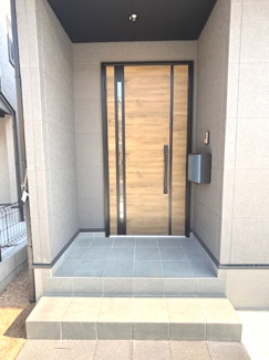【玄関】 | 安芸区中野6丁目（中野東駅）【外構込み価格♪】NO2　 | シックな色合いのタイルで仕上げられた、高級感漂う玄関アプローチです。軒が深く設計されているため、雨の日でも濡れにくく、落ち着いて鍵の開け閉めや荷物の整理が行えます。