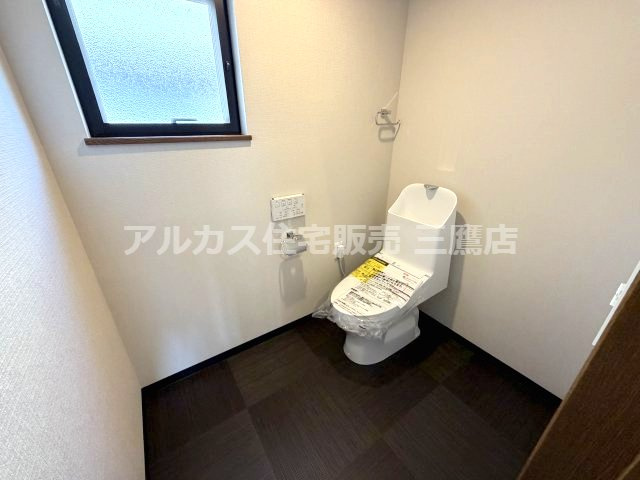 府中市紅葉丘1丁目 西武多摩川線 白糸台駅 中古戸建のトイレ|落ち着いたシックな床面デザインとホワイトの壁面が調和した、広さにゆとりのあるトイレ空間。