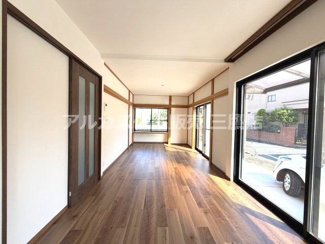 府中市紅葉丘1丁目 西武多摩川線 白糸台駅 中古戸建の居間・リビング|大きな開口部から明るい光が広がる、深みのあるフローリングが美しいリビングスペース。