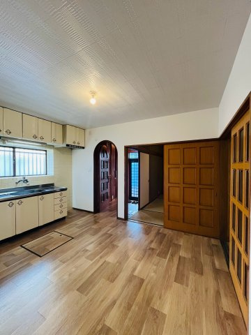 城東区今福南２丁目中古戸建の居間・リビング|DK（約7.8帖）：玄関との接続部分はアール壁で、建具の色合いも相まってレトロな可愛らしさがあります。