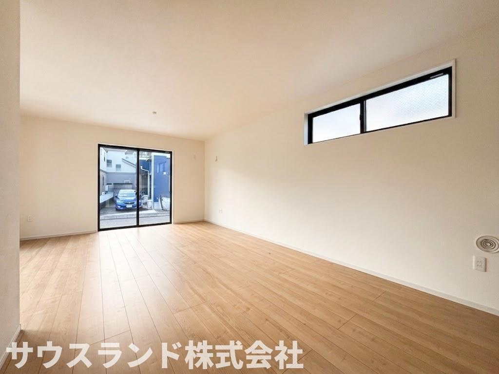 八王子市東浅川町6期１号棟の居間・リビング|大きな窓からたっぷりと自然光が差し込む明るいリビングダイニングです。ご家族みんなでゆったりとくつろげる広さが確保されています。ナチュラルな色合いのフローリングが、温かみのある空間を演出しています。