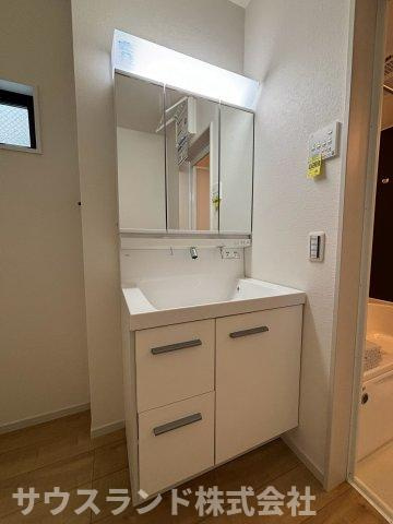 八王子市東浅川町6期１号棟の独立洗面台|大きな鏡と明るい照明が備わった使いやすい独立洗面台です。洗面ボウルが広いため、お子様の手洗いやちょっとしたお洗濯にも便利です。鏡の裏や足元には豊富な収納スペースがあり、小物類もすっきり片付きます。