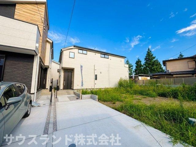 八王子市東浅川町6期2号棟の外観|青空に映えるシンプルでモダンな外観デザインです。カースペースが確保されており、大きなお買い物やお子様の送迎など、お車での移動が多いご家庭も安心。前面道路からの車の出し入れもスムーズに行えます！