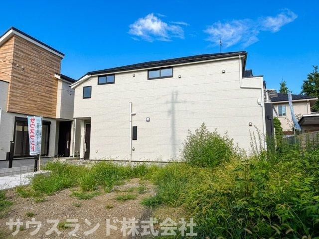 八王子市東浅川町6期2号棟の外観|青空と建物のコントラストが美しく映える外観です。アプローチ部分もすっきりと整備されており、ベビーカーの移動などもスムーズに行えます。日当たりが良く、明るい光が室内までしっかりと届く住まいです。