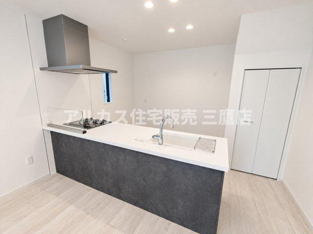 調布市東つつじケ丘2丁目 新築戸建 京王線 つつじヶ丘駅 のキッチン|リビング全体が見渡せる対面式キッチン。お部屋の雰囲気を引き締めるシックなカラーのアクセントパネルを採用しています。