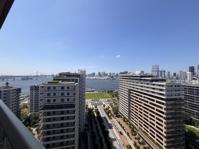 バルコニーからの心地よい眺望写真です。眼下には美しい東京湾が広がり、レインボーブリッジを望む爽快なパノラマビューをお楽しみいただけます。都市と海が調和した、開放感あふれる贅沢なロケーションです。