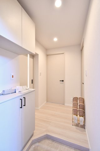 春日部ハウス1号棟の玄関|玄関から室内へ続く廊下、動線が見える写真。各室へつながる動線が明確で暮らしを整理しやすい一角。全室フローリングリフォーム済(2026年9月)です。内覧で収納・採光・動線を確認ください。
