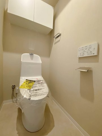 ベウラ大泉学園のトイレ|快適な温水洗浄便座付きトイレへ新規交換。手洗い付きで使い勝手が良く、お掃除もしやすいスッキリとしたデザインです。上部にはトイレットペーパー等のストックに便利な吊戸棚収納を完備しています。