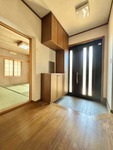 近江八幡市新町1丁目　中古戸建ての玄関|・玄関収納を備えた、ゆとりを感じる玄関ホール
・隣の和室へも移動しやすく、来客を迎える際にも便利な配置
・靴や外出用品を収納しながら、家族が毎日使う玄関まわりをすっきり整えやすい空間です