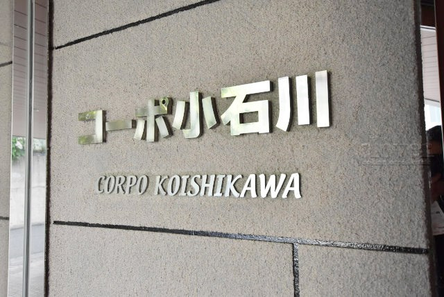 【現況写真】 | コーポ小石川 | エントランスに掲げられた、マンション名を示す館銘板。さほど激しく主張はしませんが、しっかりと掲示されています。～即日のご見学可能～　お問合せはお気軽にどうぞ。
