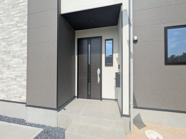 水戸市酒門町16期　新築戸建　1号棟の玄関|お洒落な玄関ドアと洗練された外壁デザイン。家の顔にふさわしい上質な佇まいで、ご家族やお客様を迎えます。