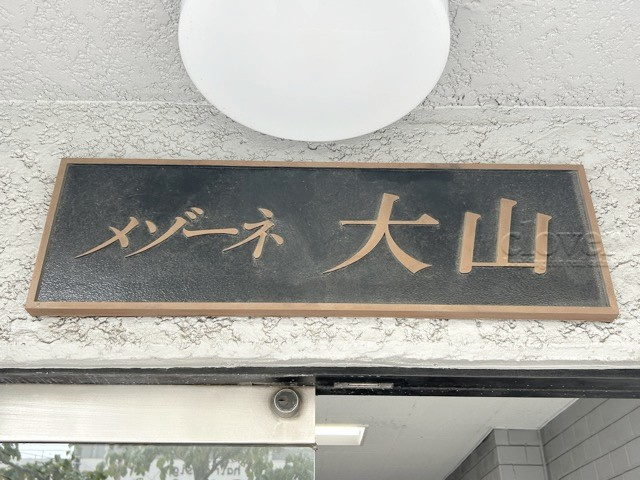 【現況写真】 | メゾーネ大山 | エントランスに掲げられた、マンション名を示す館銘板。さほど激しく主張はしませんが、しっかりと掲示されています。～即日のご見学可能～　お問合せはお気軽にどうぞ。