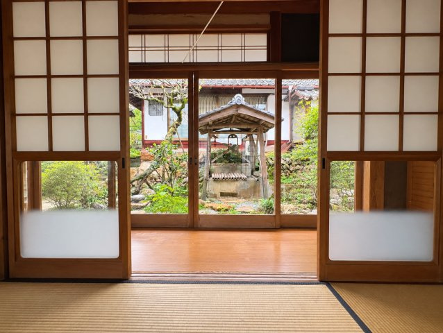 京丹波町須知　母屋・離れと白い蔵のある家の和室|2つの庭に面した母屋の6畳和室から、井戸のある庭を望む。明るく落ち着いた空間です。