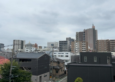 【展望】 | パークサイド町田 | 6階部分からの眺望写真です。前面に遮るものがなく、開放的な景色と豊かな陽光が広がります。原町田ふるさとの森の緑を感じられる周辺環境で、季節の移り変わりをバルコニーから楽しむことができます。