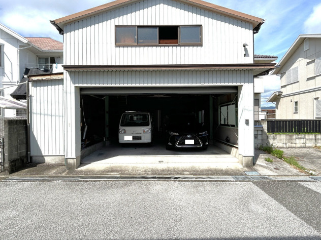 「車好きにはたまらないガレージ付」香南市野市町みどり野東3丁目　中古一戸建ての駐車場|お車を2台ゆったりと格納できる貴重なシャッター付きガレージ。雨風や日差しから大切なお車を守れるほか、DIYの作業スペースやアウトドア用品の収納など、趣味の空間としても大活躍します！