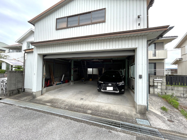「車好きにはたまらないガレージ付」香南市野市町みどり野東3丁目　中古一戸建ての駐車場|車2台をゆとりをもって駐車できるワイドなビルトインガレージ。シャッターを閉めれば防犯面も安心です。前面道路との接道もスムーズで、日々の車の出入りや荷物の出し入れも楽に行えます。