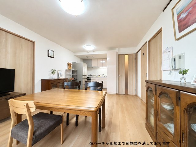 ライオンズマンション旭ヶ丘の居間・リビング|キッチンからリビングまでひとつながりになった開放的な空間。穏やかな色合いの建具で、