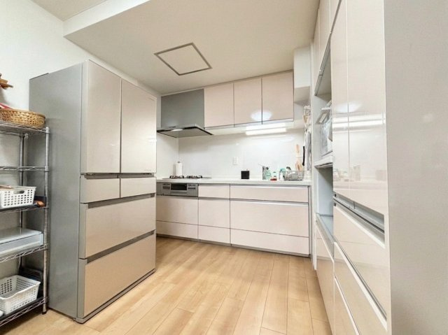 ライオンズマンション旭ヶ丘のキッチン|淡い色合いでまとめられた、明るく清潔感のあるシステムキッチン