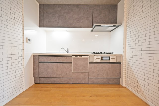日商岩井京橋ハイツのキッチン|壁付けキッチンを採用し、LDKのスペースを有効に活用した使い勝手の良い空間。キッチンまわりがすっきりとまとまっているため、ダイニングのスペースを広く確保しやすく、家具の配置も自由度が高まります。