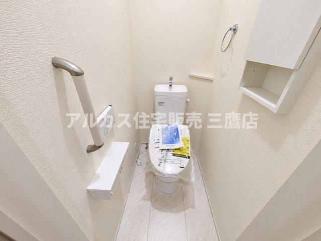 小平市学園東町3丁目　西武多摩湖線　一橋学園駅　新築戸建のトイレ|立ち座りをサポートする手すりや壁面棚が設置された、快適に使用できるトイレです。