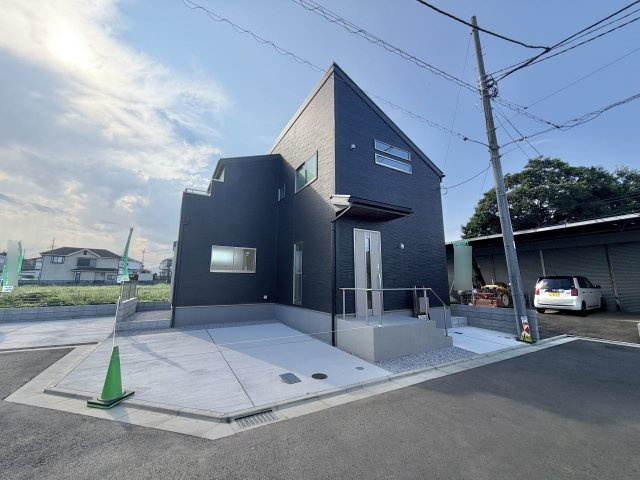 あきる野市上代継全6棟の外観|ダークグレーのお洒落な新築分譲住宅の外観写真です。 明るい日差しの中で、洗練されたデザインが目を引きます。駐車場スペースもあり、快適な生活が想像できる物件です。