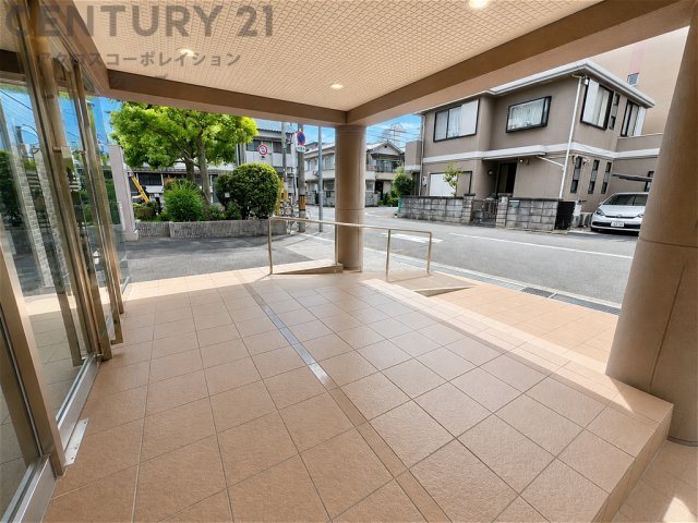 ゆとりあるアプローチが印象的なマンションエントランス。段差に配慮したスロープも設けられ、ベビーカーや車椅子での移動もスムーズ。毎日の暮らしに安心と快適さを添えます。