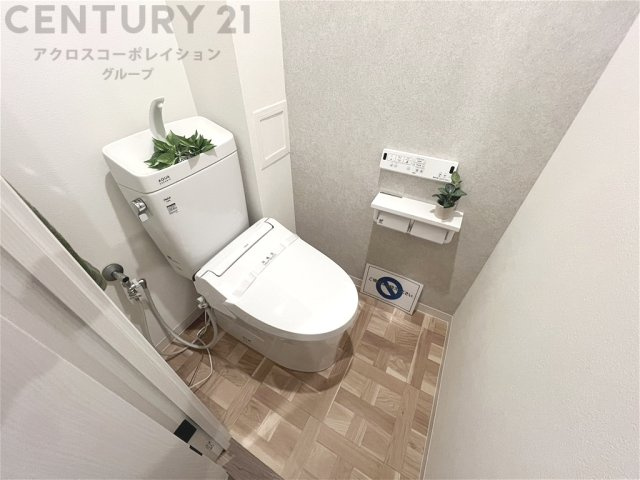 清潔感のある明るいトイレ空間。温水洗浄便座を備え、快適にお使いいただけます。やさしい色合いの内装で、毎日気持ちよく過ごせる落ち着いた空間です。