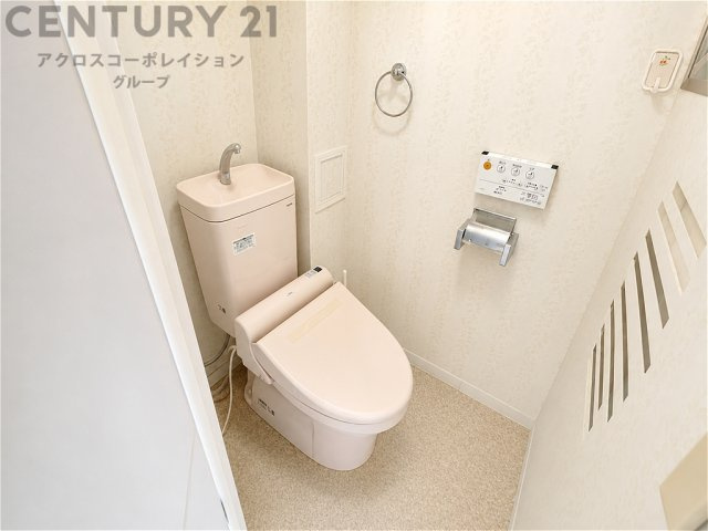 清潔感のある明るいトイレ空間。温水洗浄便座を備え、快適にお使いいただけます。やさしい色合いの内装で、毎日気持ちよく過ごせる落ち着いた空間です。