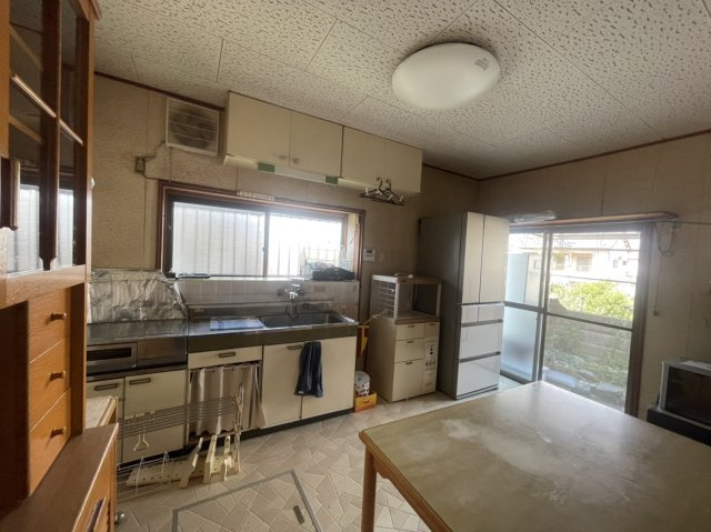 朝日ケ丘二丁目戸建のキッチン|窓から明るい光が差し込むダイニングキッチンは、調理後すぐに食事を運べる便利な動線が魅力です。