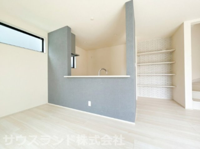 八王子市元横山町第1期 新築戸建ての居間・リビング|奥行きと開放感を感じられる広々としたLDK空間です！シックなアクセントクロスが落ち着いた雰囲気を演出し、キッチン横の可動棚には書類や小物類を綺麗に収納できてお部屋全体をすっきり保てます。