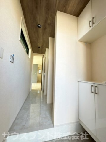 八王子市元横山町第1期 新築戸建ての玄関|天井の木目調クロスがお洒落な開放感のある玄関ホールです。上下に分かれたシューズボックスを備えており、ご家族全員の靴をすっきりと収納できるほか、カウンター部分には小物を飾ることもできます。