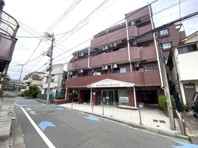 ライオンズマンション王子第６の外観|落ち着いた色合いの外観デザインが印象的なマンションです。周辺環境と美しく調和しており、管理体制の良さが感じられます。前面道路も整っており、毎日の通勤・通学も快適に行える住環境です。