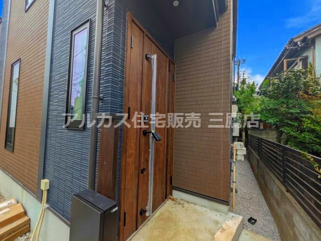 小平市仲町 西武新宿線　小平駅　新築戸建の玄関|重厚感のある木目調の玄関ドア。雨除けになる庇（ひさし）付きで、雨の日の出入りもスムーズです。