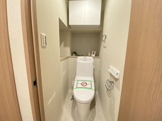 ベイサイトコート横浜のトイレ|温水洗浄便座のトイレ設備です。奥行きの有るゆったりしたスペースには飾り棚や吊戸棚があり収納も便利です