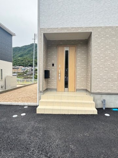 【玄関】 | 安佐北区亀山8丁目（全2区画）No１ | すっきりとしたステップと木目調の玄関ドアが温かみを感じさせるアプローチ。ポーチ部分には屋根が架かっているため、雨の日でも慌てることなく落ち着いて鍵の開け閉めができます。