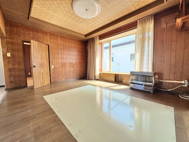 【角地の開放感】昭和エリアの利便性と、木の温もりあふれる室内が魅力の住まいの居間・リビング|陽光が差し込む広々リビング。家族の時間を育む落ち着いた内装。