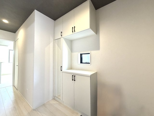 越谷市船渡２期１号棟グラファーレ　新築戸建の玄関|姿見付きで身支度のチェックに便利。収納力豊富なシューズボックスを備えています。