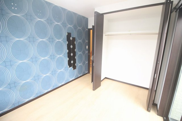 小山市出井の寝室|ブルーのアクセントクロスが印象的な洋室。クローゼットもしっかり備わり、好きなインテリアを合わせて自分らしいお部屋づくりを楽しめます。水玉に見えるところは姿鏡です。
