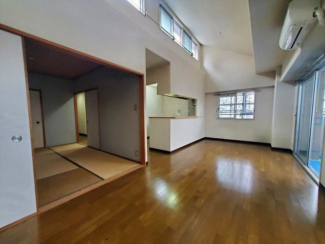 「勾配天井が創る大空間」高知市比島町1丁目サーパス北本町　中古マンションの居間・リビング|広々リビング＆和室隣接。ハイサイドライトから光が差し込む高天井空間。畳スペースでゴロ寝も快適♪