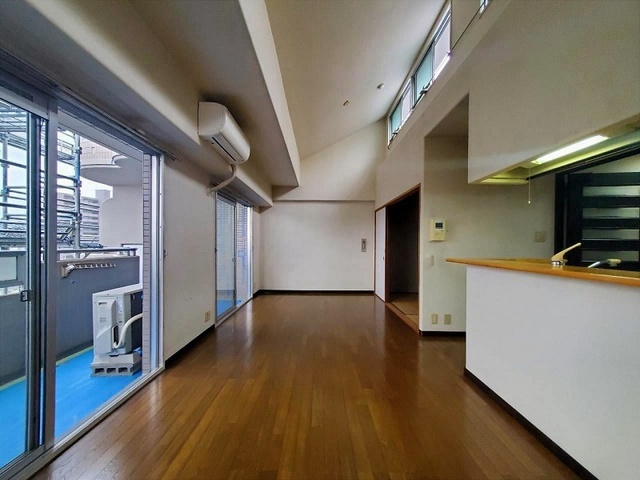 「勾配天井が創る大空間」高知市比島町1丁目サーパス北本町　中古マンションの居間・リビング|開放感あふれるLDK。バルコニーへ続く大きな窓と吹き抜け風の高天井が魅力！明るく心地よい大空間。