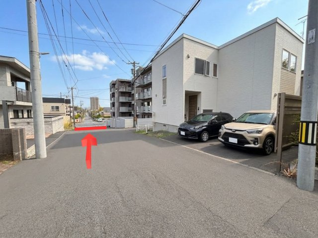 山の手1条12丁目　一戸建ての前面道路含む現地写真|矢印先が「北一・宮の沢通」となります。傾斜が少ない立地で、都心部へのアクセスも快適です