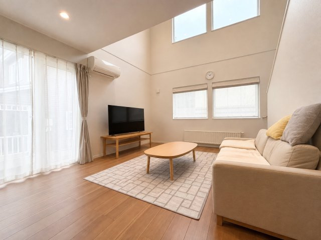 山の手1条12丁目　一戸建ての居間・リビング|大きな吹き抜けが印象的な19帖の広々LDK。陽射しが差し込む、明るい空間。大型家具も配置可能です